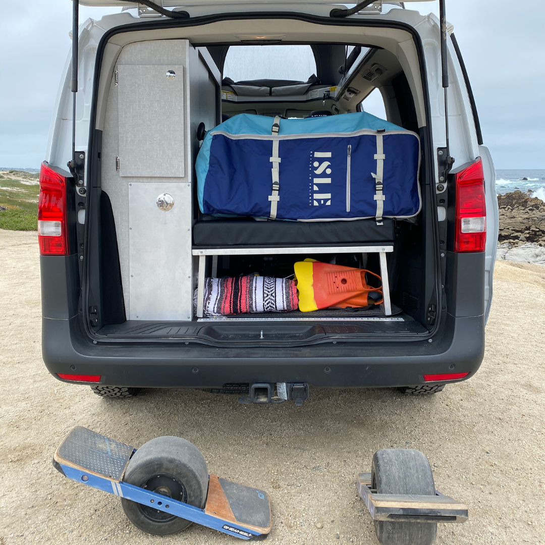 paddle boards and one wheels in back off campervan