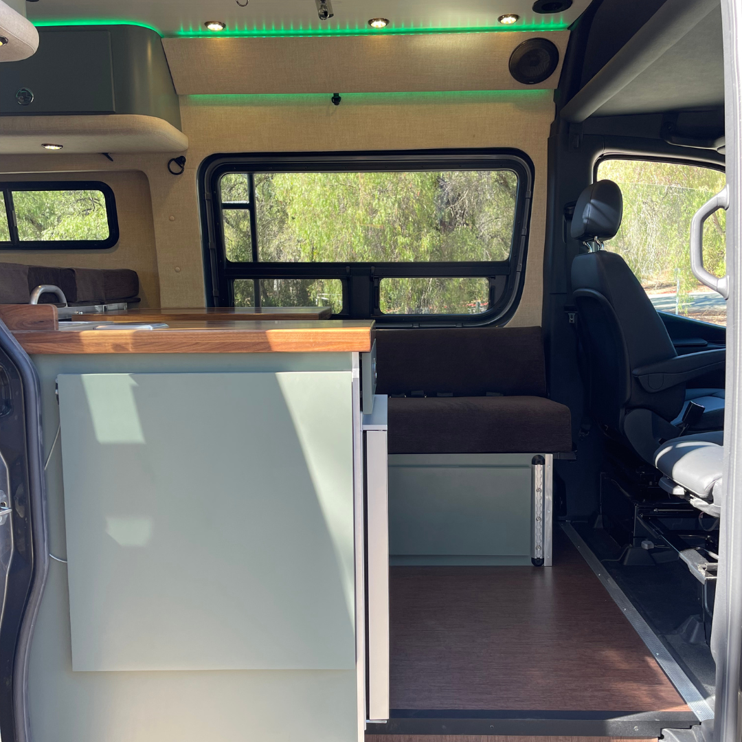 the interior of a campervan with a couch and countertop