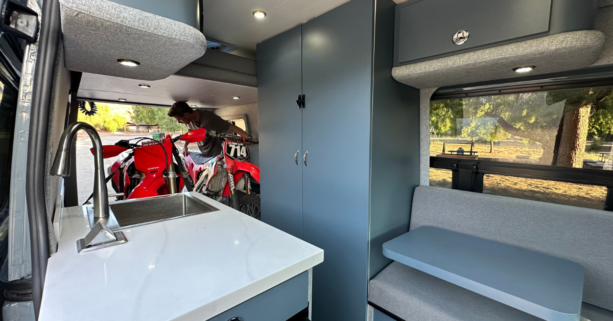 two motocross bikes in the back of a campervan