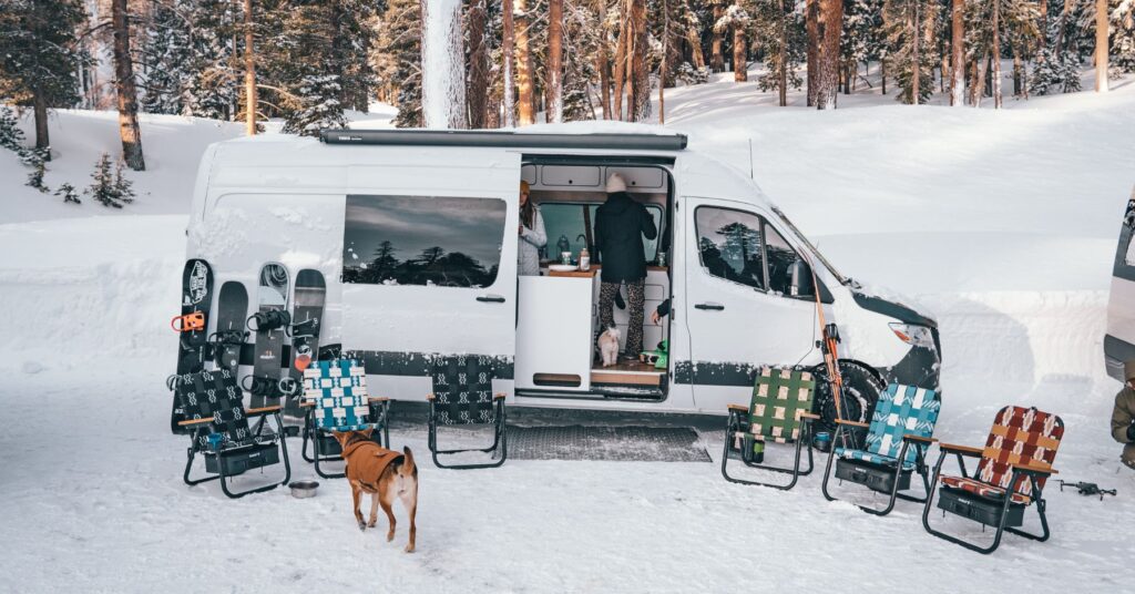 a van in the snow with chairs surrounding it.