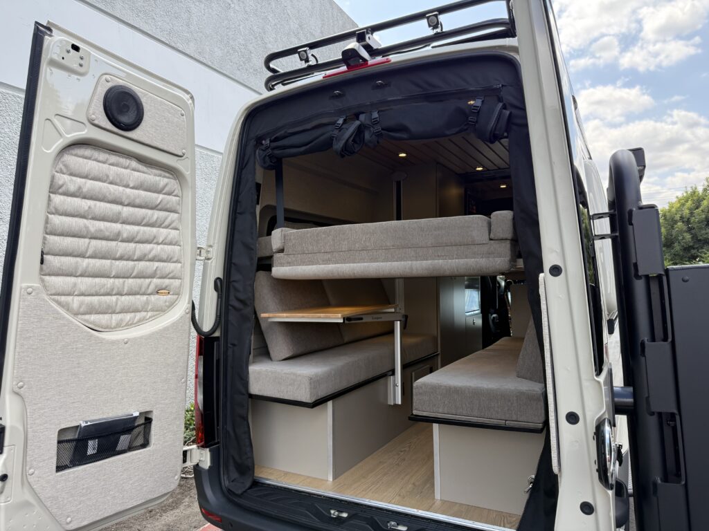 the back of a campervan with a drop down bed and dinette layout